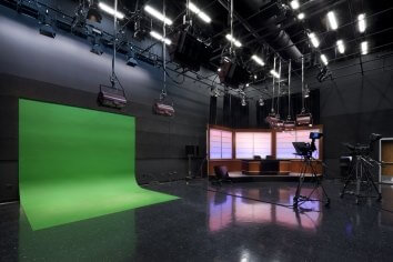 Broadcasting room with a green screen, cameras, and set