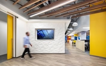 Corgan LA interior with a man walking through a yellow and white space