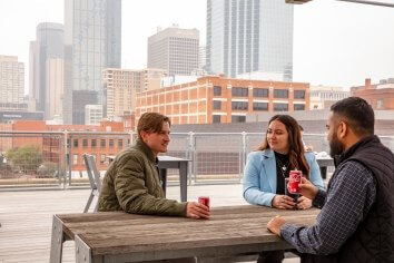 Meghan Davis and DC team members sitting on Dallas's rooftop