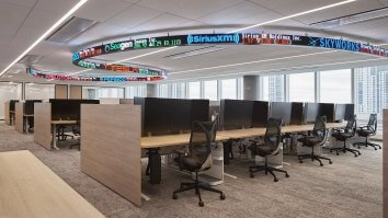 Workspaces sit under a stock ticker attached to the ceiling