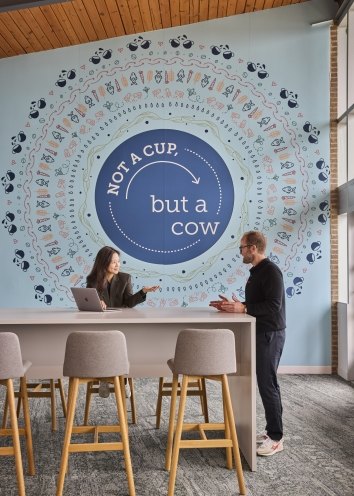 Branded wall in office space with people talking